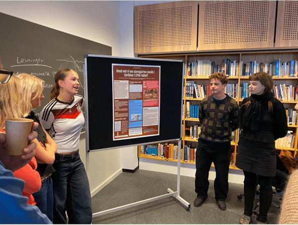 Gymnasium students presenting their poster to peers and researchers.